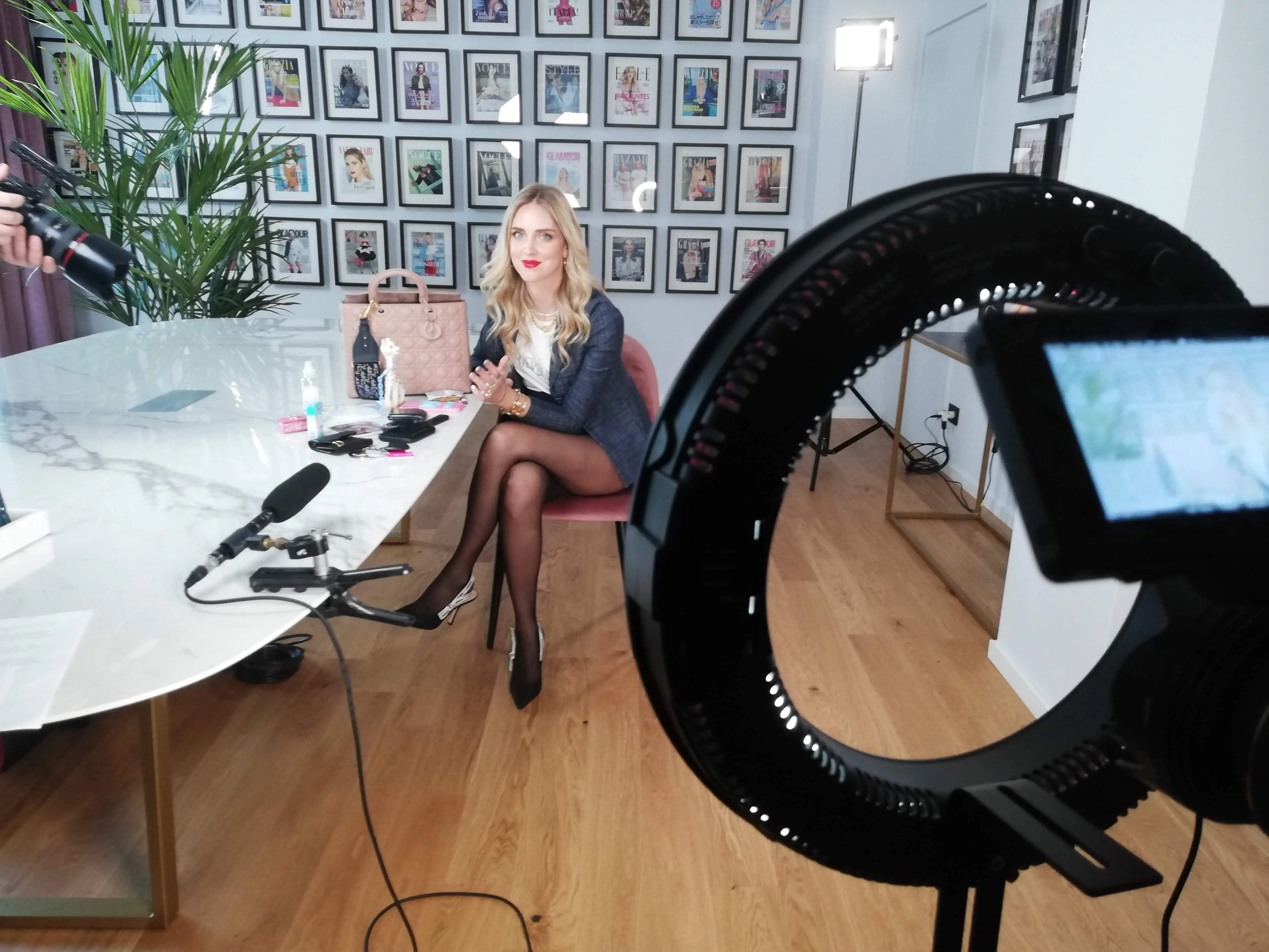 Ring light and cinema camera set up for an interview on a Dior shoot, with a handbag on the table in the background