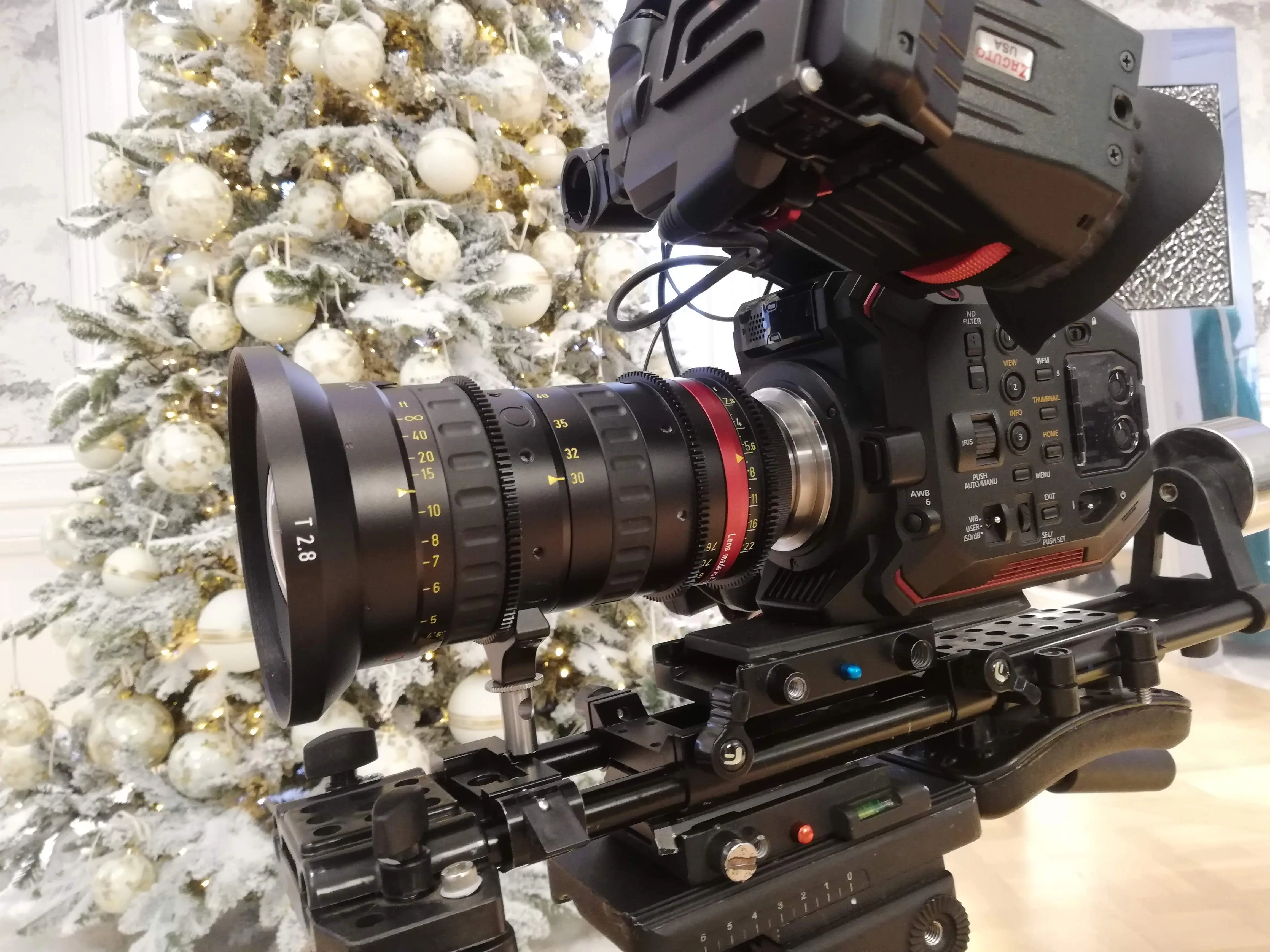 Cinema camera with a cine zoom rigged in front of a decorated Christmas tree on a Dior holiday shoot