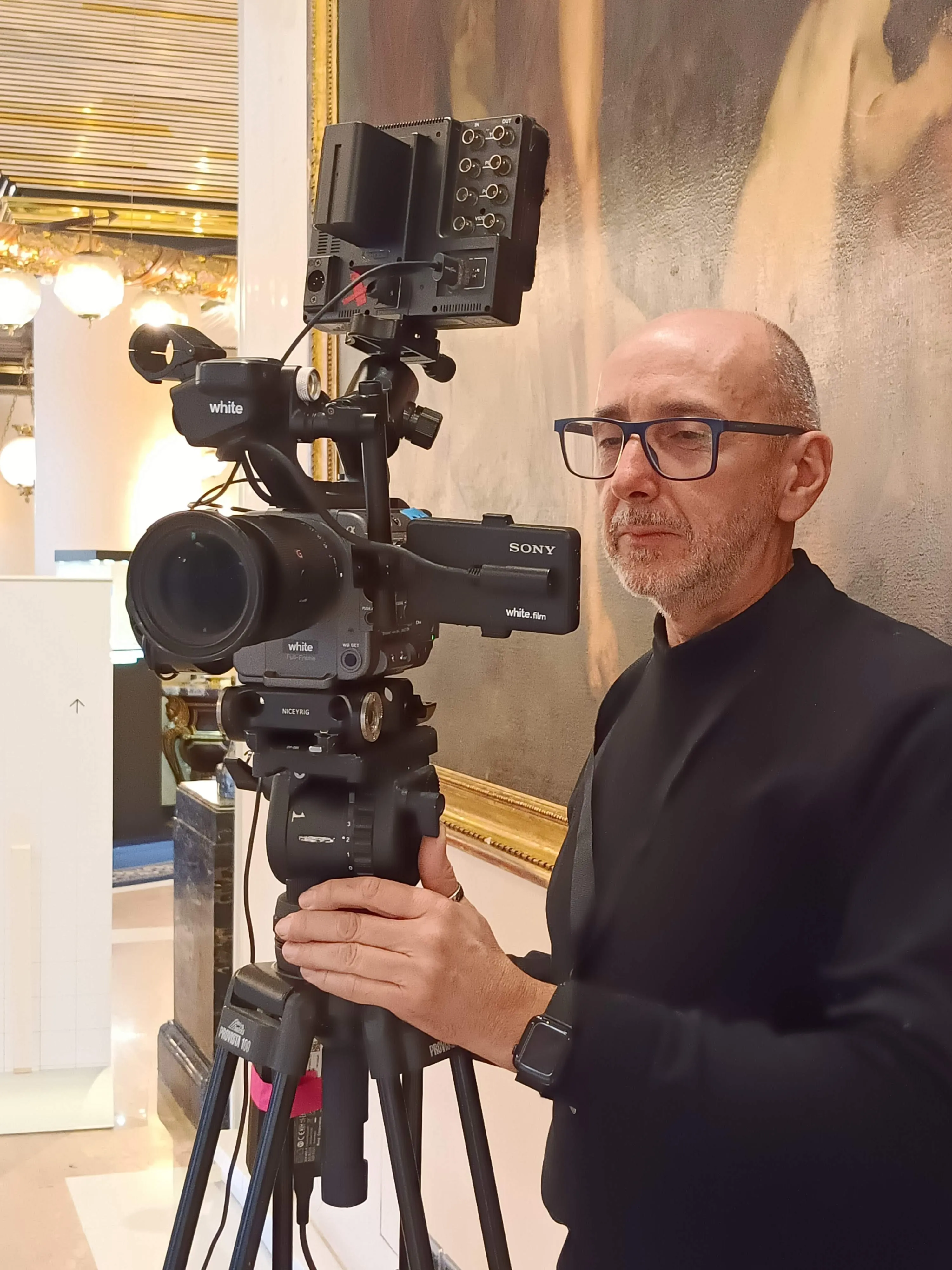 An operator behind a Sony FX9 hired from White Film, rigged with an audio mixer and a field monitor