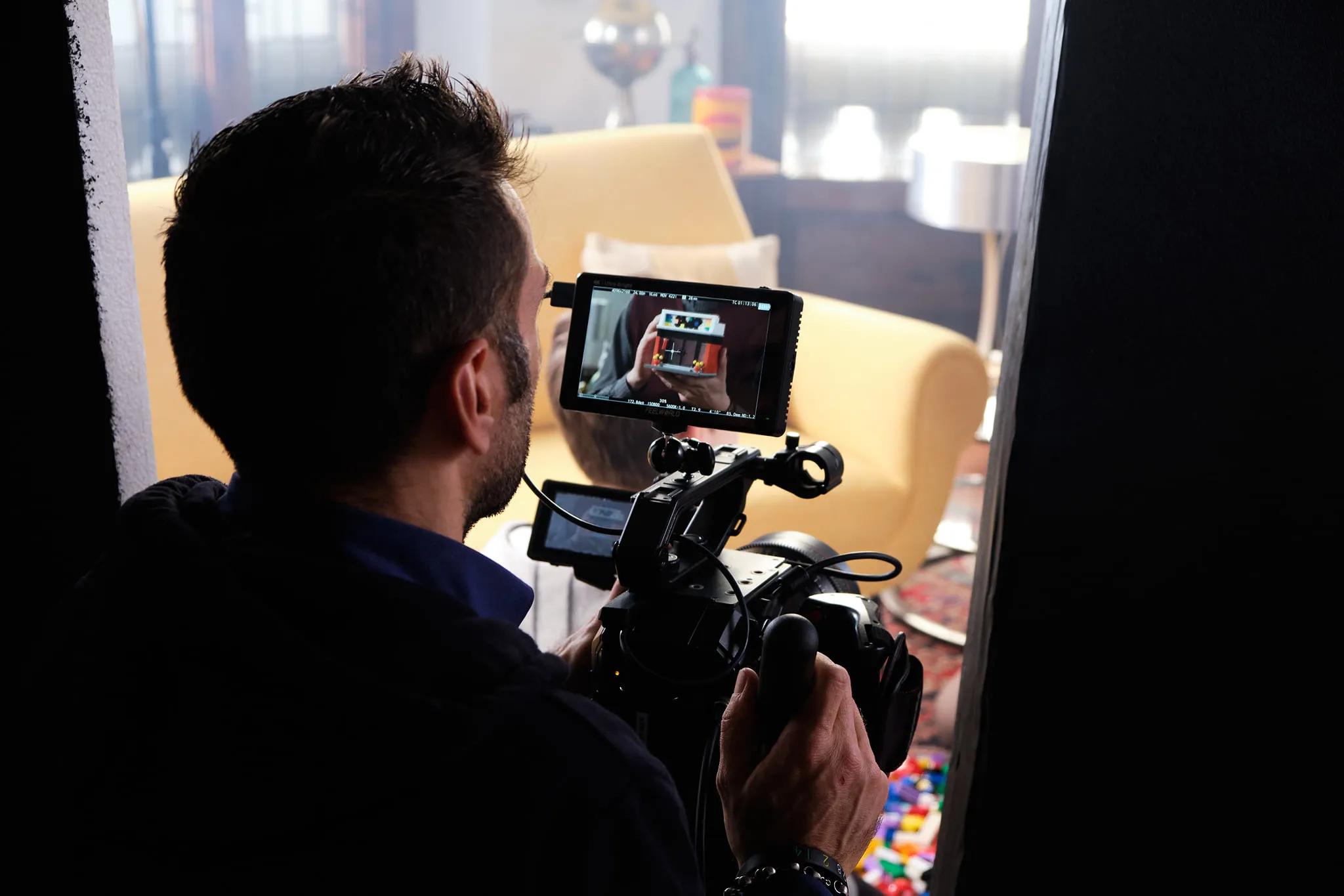 Matteo Castelli operating a cinema camera behind a Feelworld field monitor during a commercial shoot