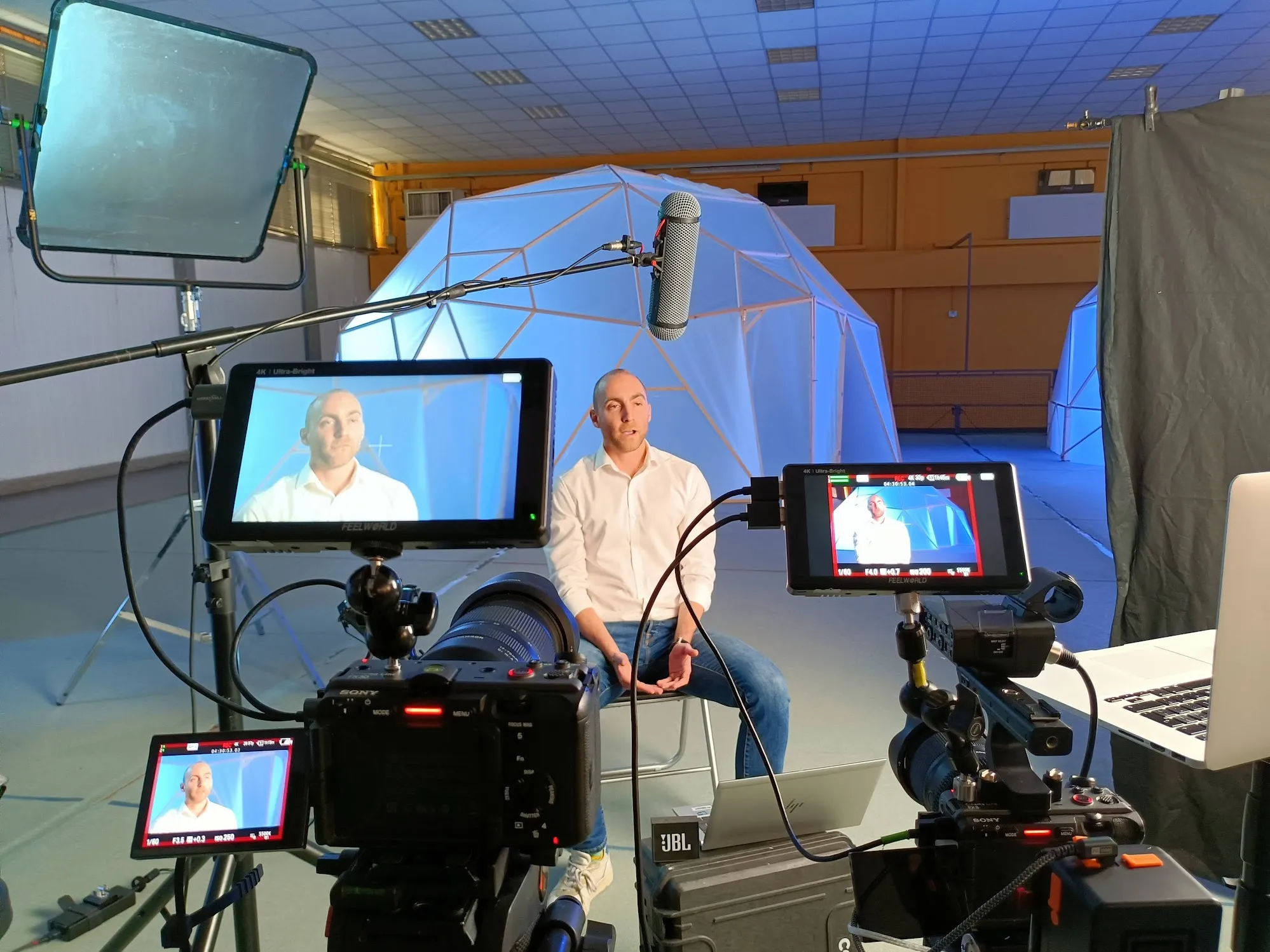Multi-camera interview setup by Matteo Castelli: two Sony cameras, Feelworld monitors, boom microphone and laptop for live streaming