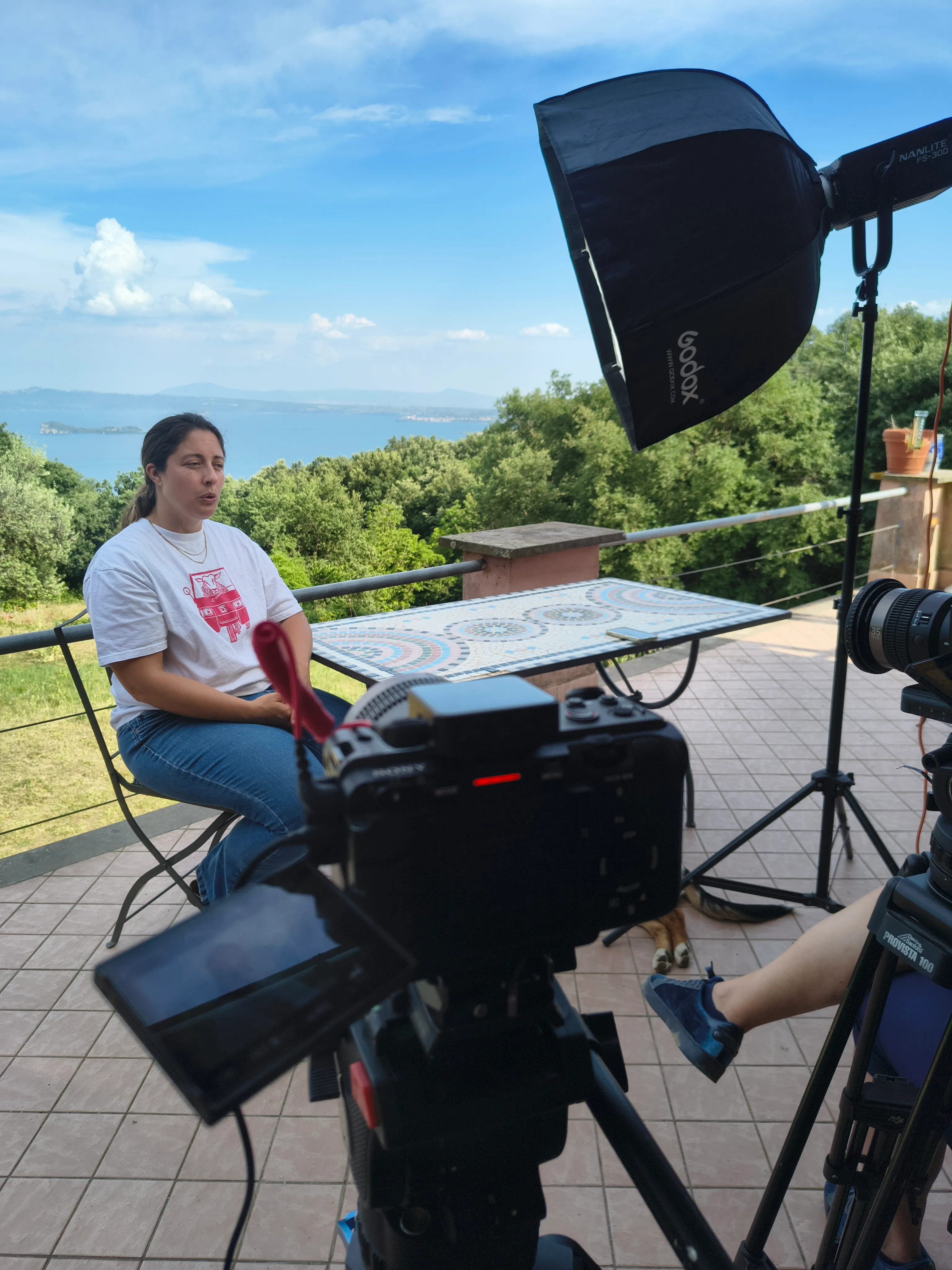 Interview on a terrace with a lake behind the subject, lit with a Godox softbox, for a Smart Move Italy documentary